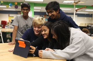Freshman applied arts students surround an ipad